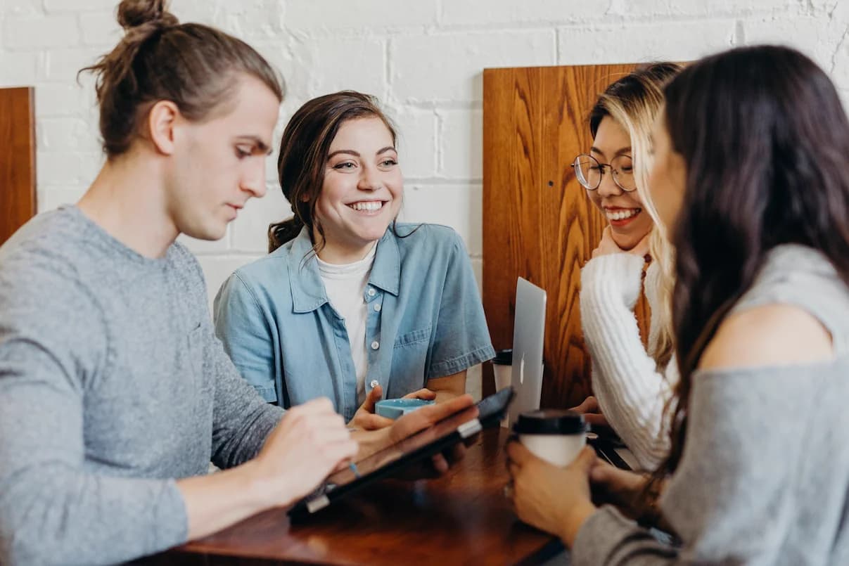 Des étudiants échangent en souriant autour d'une table